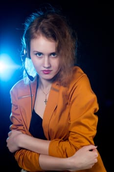 Young beautiful woman-operator with headphone smiles, it is isolated on black background.