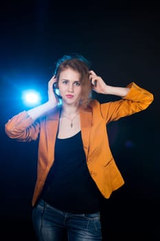Young beautiful woman-operator with headphone smiles, it is isolated on black background.