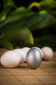 Silver and white Easter eggs with wood background