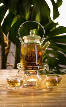 Chinese teapot with tea, on a burning support from glass