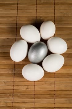 Silver and white Easter eggs with wood background