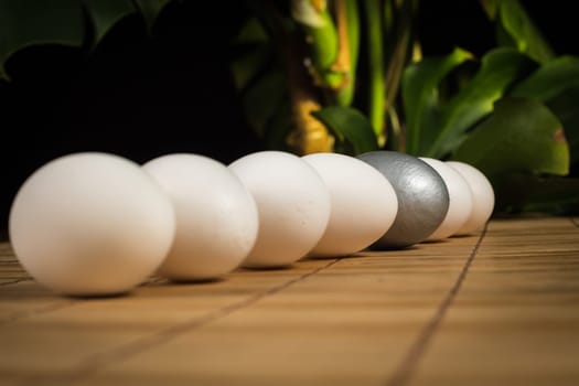 Silver and white Easter eggs with wood background