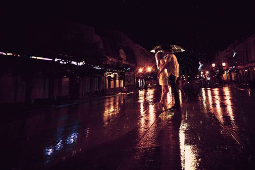 Love in the rain / Silhouette of kissing couple under umbrella