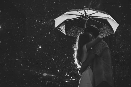 Love in the rain / Silhouette of kissing couple under umbrella
