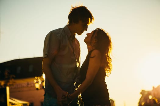 Young couple kissing over sunset