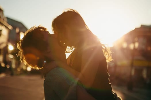 Young couple kissing over sunset