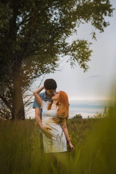 Happy young couple kissing on a ripe field