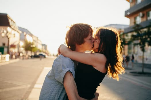 Young couple kissing over sunset