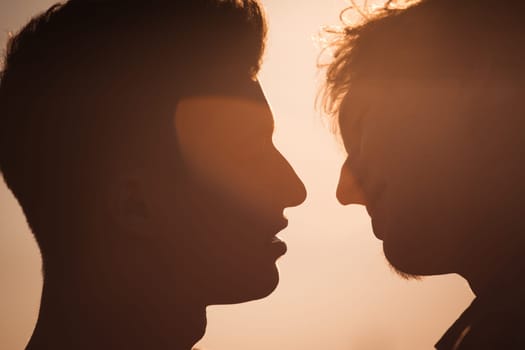 Silhouette of two men about to kiss