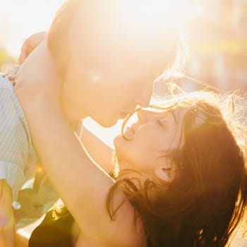 Young couple kissing over sunset