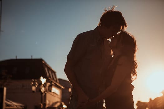 Young couple kissing over sunset