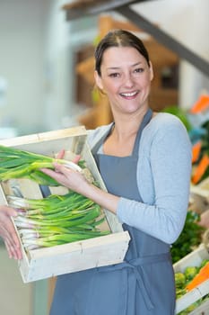 smiling female seller in vegetables market