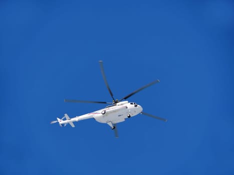 helicopter Mi-8MTV flies in the blue sky blurry motion