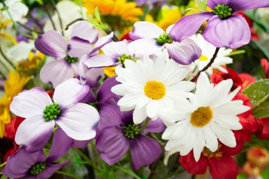 Artificial colorful bouquet with leaves, interior design a row of bouquets in a flower shop, decoration artificial flower fabric rose bouquet backdrop