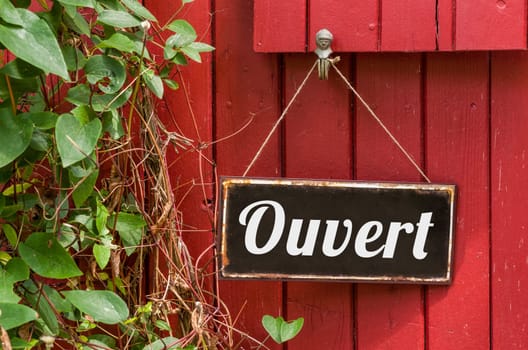 Old metal sign with the inscription Open in french - Ouvert