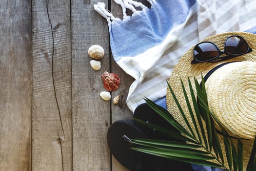 Concept of travel, vacation or weekends. Straw hat with palm leaf, shoes and eyeglasses, towel on wooden background. Relax time. High quality photo