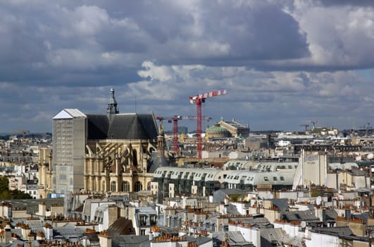 The rooftops of Paris under a threatening sky. In the distance the church of St Eustache. (Paris, France)