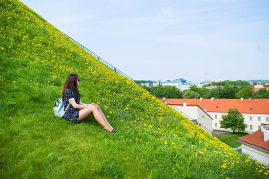 Girl sitting and looking down on old city Vilnius - Lithuania.