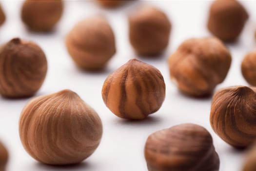 Hazelnuts scattered on a white background, whole, selective focus. The concept of healthy eating.