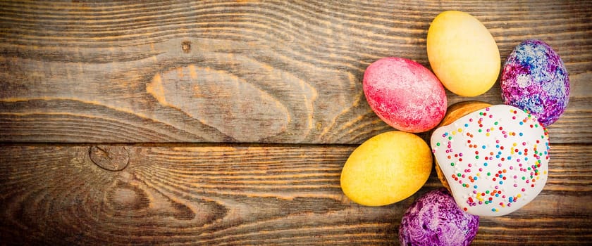 Easter cakes and Easter colored eggs on a wooden background. Religious holiday of bright Easter.