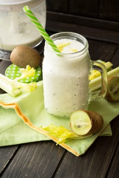 Vegetarian preparing vegan smoothie with kiwi, celery, cucumber close up. Vertical image