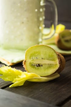 Detox concept from kiwi and celery, a glass jar of fresh kiwi smoothie on a black background. Vertical image