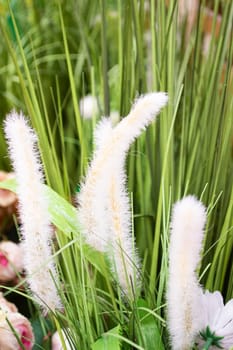 branches of artificial grass made of polystyrene foam on the green grass. Vertical image