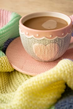 Cup with cappuccino, pastel colorful plaid. Morning concept, vertical image