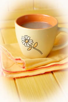 orange cup of cappuccino or coffee on wooden table, vertical image