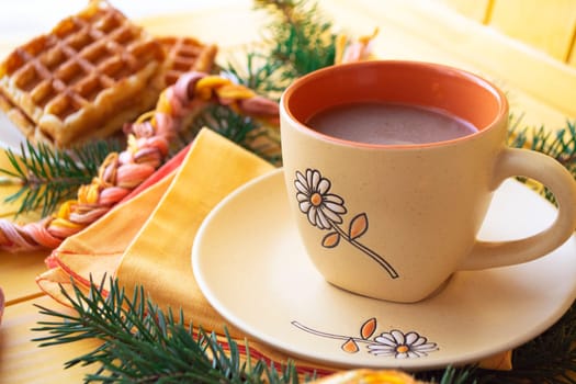 Coffee orange cup of latte with some waffle on wooden table