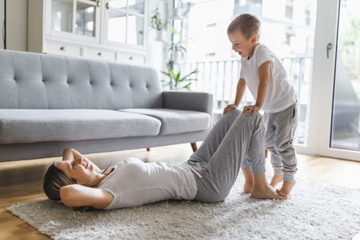 Mom with her young son working out in the living room