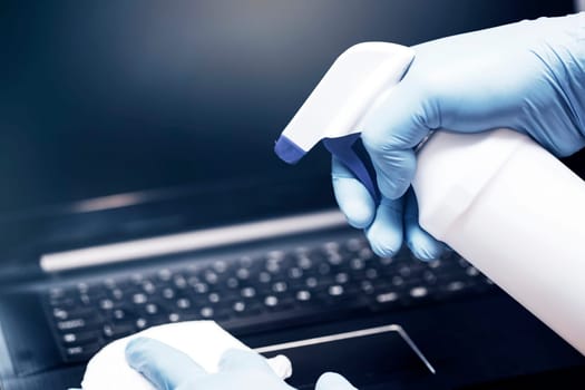 Coronavirus COVID-19 sanitize cleaning disinfection of work desk.Office sanitizing wipe wiping laptop with disinfecting wipes.