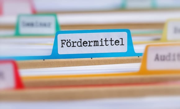 File folders with a tab labeled Funding in german - Fördermittel