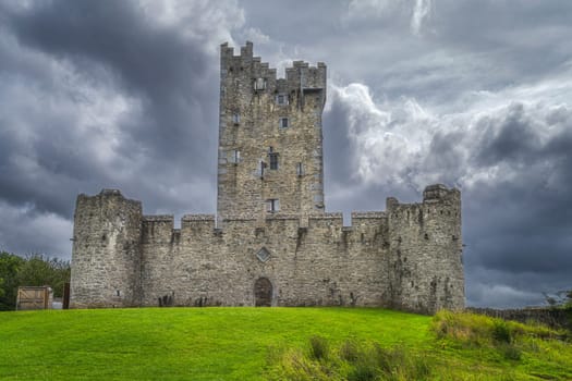 Front view on old keep from 15th century, Ross Castle located on the bank of Lough Leane with dramatic storm clouds, Ring of Kerry, Killarney, Ireland