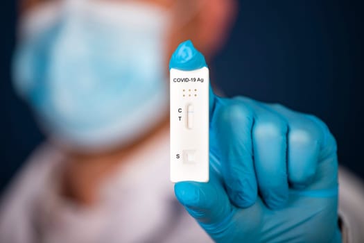 Doctor holding a test kit for viral disease COVID-19. Lab card kit tested NEGATIVE for viral novel coronavirus sars-cov-2 virus.