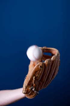 Close up image of an old used baseball and baseball glove.
