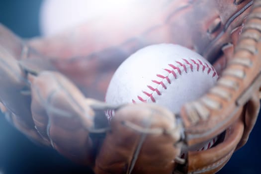 Close up image of an old used baseball and baseball glove.