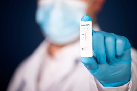 Doctor holding a test kit for viral disease COVID-19. Lab card kit tested NEGATIVE for viral novel coronavirus sars-cov-2 virus.