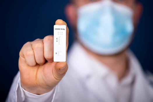 Doctor holding a test kit for viral disease COVID-19. Lab card kit tested NEGATIVE for viral novel coronavirus sars-cov-2 virus.