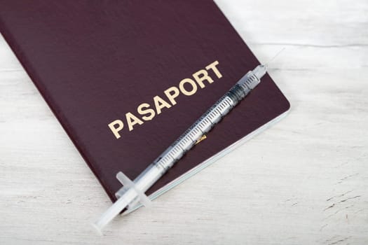 Travel restrictions concept for people without corona virus vaccination with syringe and travel passport