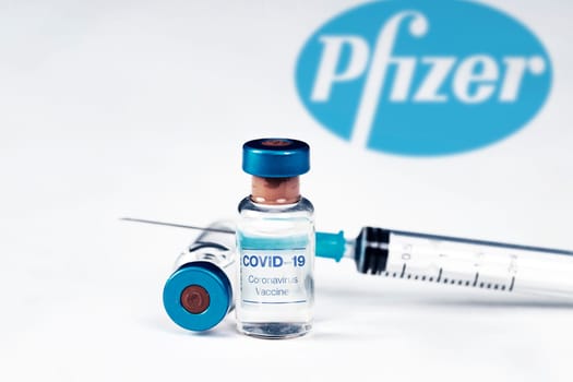 Cluj-Napoca, Romania - March 15, 2021:  New coronavirus vaccine Pfizer concept, blurred Pfizer logo on the background. Covid-19, 2019-nCov pandemic.