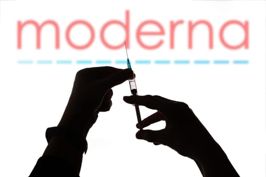Cluj-Napoca, Romania - March 15, 2021:  New coronavirus vaccine Moderna concept, blurred Moderna logo on the background. Covid-19, 2019-nCov pandemic.