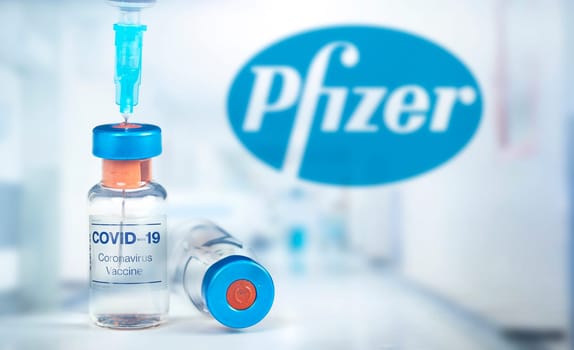 Cluj-Napoca, Romania - March 15, 2021:  New coronavirus vaccine Pfizer concept, blurred Pfizer logo on the background. Covid-19, 2019-nCov pandemic.