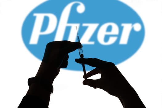 Cluj-Napoca, Romania - March 15, 2021:  New coronavirus vaccine Pfizer concept, blurred Pfizer logo on the background. Covid-19, 2019-nCov pandemic.