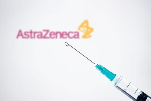 Cluj-Napoca, Romania - March 15, 2021:  New coronavirus vaccine Astra Zeneca concept, blurred Astra Zeneca logo on the background. Covid-19, 2019-nCov pandemic.