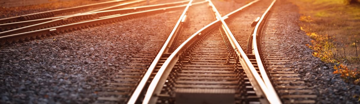 Railway track in the evening in sunset. Panoramic view on the railroad switch.