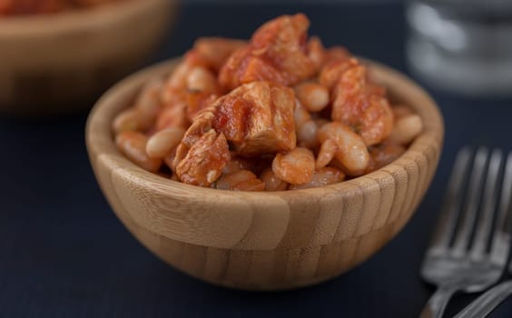 Steamed white beans with meat in tomato sauce. Homemade food concept. Close up. Selective focus.