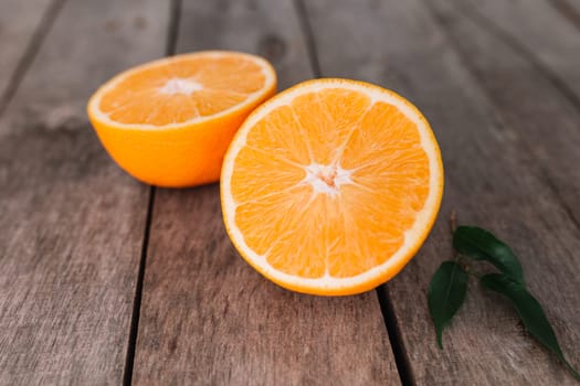 Flat lay with fresh ripe sliced halves of orange fruit on gray wooden background. Orange pulp and green leaves. Tropic food concept. Healthy eating concept. High quality photo
