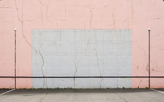Cracked Basque pelota wall, pink and grey colours.