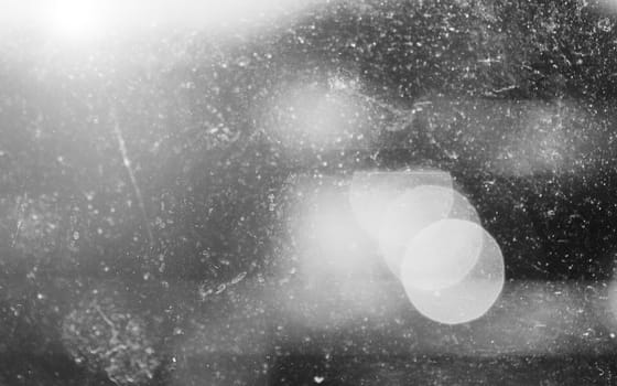 Black and white abstract dirty glass texture and bokeh background, grungy glass, lens flare and bokeh balls.